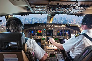 Two captains flying an airplane in a cockpit 